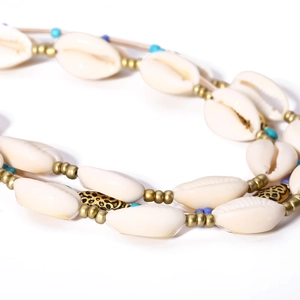 Detailed close-up of Bohemian necklace with shells, blue beads and gold leopard accents