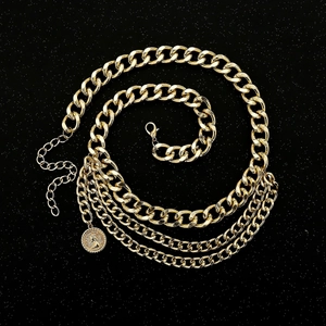 Detail einer mehrlagigen goldenen Metall-Taillenkette mit Vintage-Münzanhänger