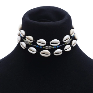Three-layer bohemian choker with white shells and colorful beads on a black display stand