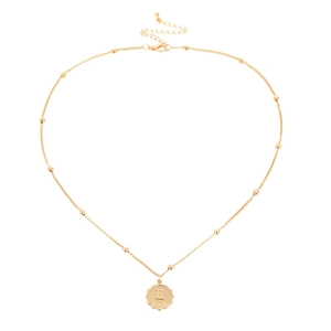 Detailaufnahme des goldenen Münzanhängers mit Gemini-Symbol und kleiner Perlenkette