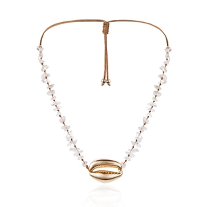 Dettaglio collana boho con perline di pietra e ciondolo a conchiglia dorata su corda marrone