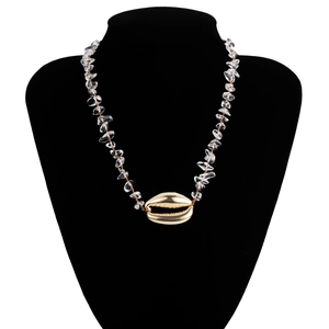 Dettaglio della collana boho con pietre di cristallo naturali e ciondolo a conchiglia d'oro