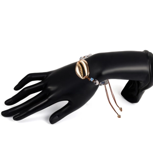 Dettaglio del bracciale boho con grande conchiglia dorata e perline di resina opale