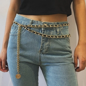 Detail of vintage gold layered waist chain with black woven leather and coin pendant