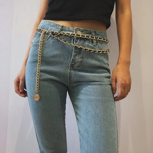 Retro multi-layer gold metal and black woven body chain with coin pendant on denim