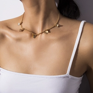 Minimalist gold thin chain necklace with delicate butterfly pendants on a model