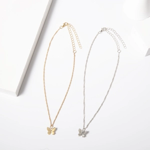 Detail view of gold and silver butterfly pendant necklaces with fine wavy chain and clasp