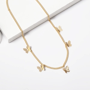Close-up of minimalist gold chain necklace featuring five delicate butterfly pendants
