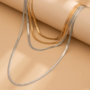 Close-up of mixed gold and silver flat snake bone chains with metallic texture