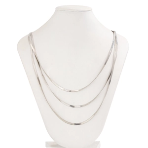 Detailed macro view of triple-layered silver snake chains on a jewelry bust model