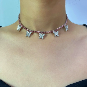 Detail view of pink rhinestone choker with silver butterfly pendants on female model neck