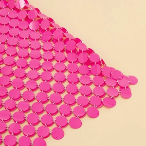 Détail de paillettes roses reliées par des anneaux métalliques pour une robe de soirée