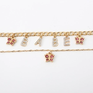 Detail of double-layer gold chain with pink rhinestone butterflies and BABE letter pendant