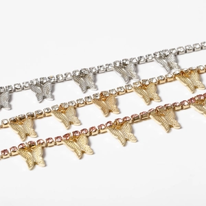 Macro detail of butterfly pendants with sparkling zircons in silver, gold, and rose gold