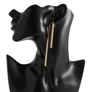 Detail of long golden snake chain fringe earrings worn on a black model silhouette