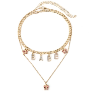 Detail of gold layered choker with BABE letter pendant and pink rhinestone butterflies