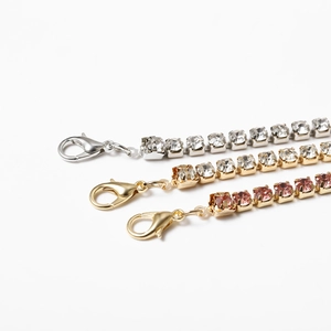 Macro shot of silver and gold tennis chains with lobster clasps and shiny zircon crystals