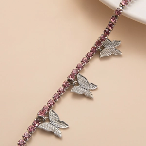 Macro view of pink rhinestone chain necklace featuring three sparkling butterfly charms