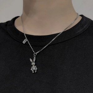 Detail of vintage silver chain necklace featuring a mechanical rabbit pendant on a black shirt