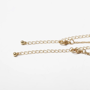 Detail of gold thin chain with lobster clasp and round ball bead for choker necklace