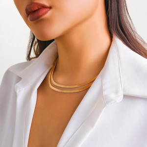 Close-up of double-layered gold snake bone chain necklace with layered metallic texture