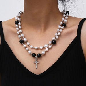 Close-up of double-layer beaded necklace with pearls and rhinestone cross pendant