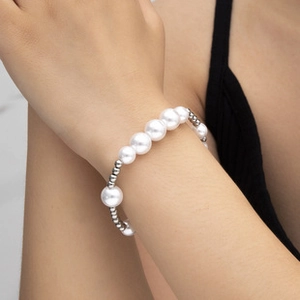 Detail of elegant pearl bracelet with gradient white pearls and silver beads on a wrist