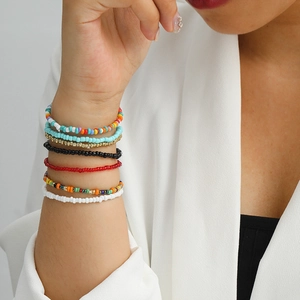 Detail of colorful multilayered bohemian seed bead bracelets on model wrist