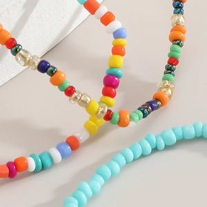 Detail of colorful Bohemian handmade seed beads and faceted glass charms on elastic bracelet
