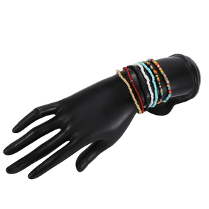 Detail view of layered colorful bead bracelets featuring multi-color stones and gold accents