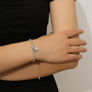 Detailed macro view of a silver butterfly necklace with sparkling crystals on a model wrist