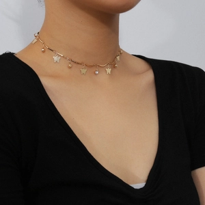 Dettaglio della collana choker a farfalla dorata con strass indossata da una modella