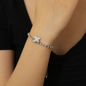 Detailed close-up of a silver butterfly tennis bracelet with micro-pave crystals on model
