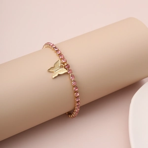 Detail of pink crystal tennis bracelet with a gold butterfly pendant on wrist stand