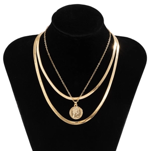 Close-up of triple-layered gold necklaces with flat snake chains and coin pendant