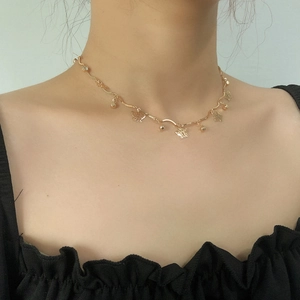 Dettaglio della collana con ciondolo a farfalla dorata indossata sulla clavicola