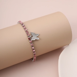Close-up of pink crystal butterfly bracelet displayed on a soft pink cylindrical stand