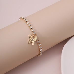 Macro detail of a gold butterfly tennis bracelet with sparkling cubic zirconia inlay