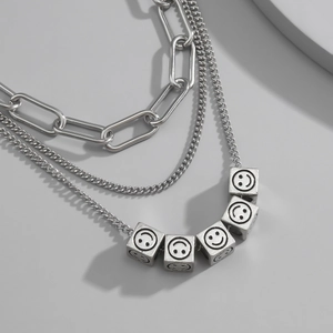 Detalle de un collar de triple capa de acero inoxidable con dados de plata antigua