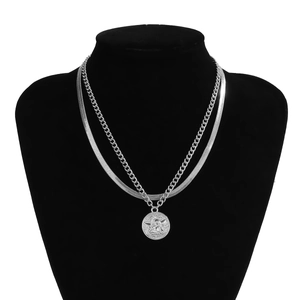 Detail of layered silver snake chain and coin pendant necklace on a black mannequin