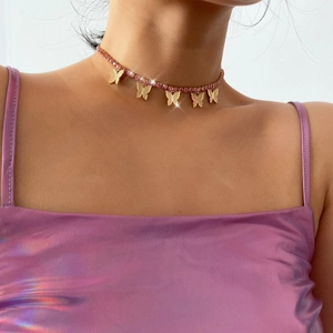 Pink rhinestone butterfly choker necklace with gold charms on a fashion model