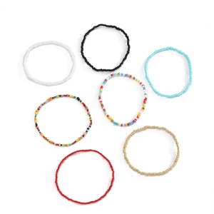 Detail view of seven colorful bohemian beaded elastic bracelets on a white background