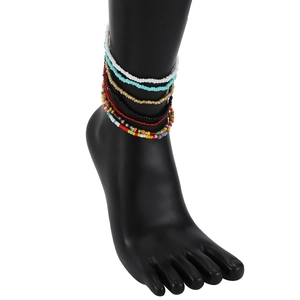 Close-up of bohemian colorful seed bead anklets set on a black display model