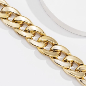 Détail macro d'un collier chaîne dorée épaisse style punk avec finition polie brillante