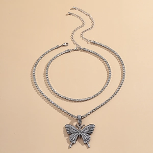 Details einer silbernen mehrlagigen Kette mit Schmetterlingsanhänger und Strass