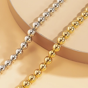 Nahaufnahme der polierten gold- und silbernen Perlen auf einer eleganten Schlangenkette