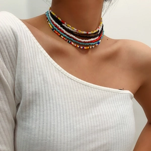Detail of colorful multilayered glass seed bead necklaces on a model's neck