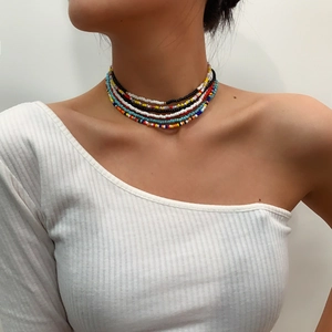 Detailed close-up of multi-layered colorful seed bead body chain on a model