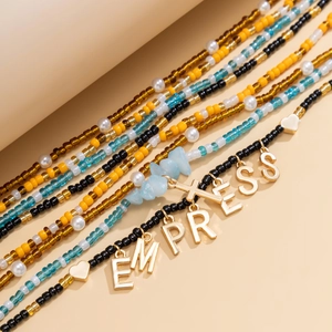 Detail of bohemian waist chain set with EMPRESS letters, colorful beads and shells