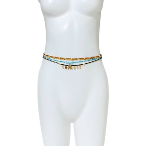 Detailed view of bohemian waist beads featuring EMPRESS gold letters and a cross charm